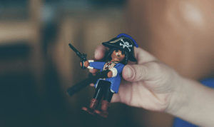 Main qui tient un Playmobil pirate